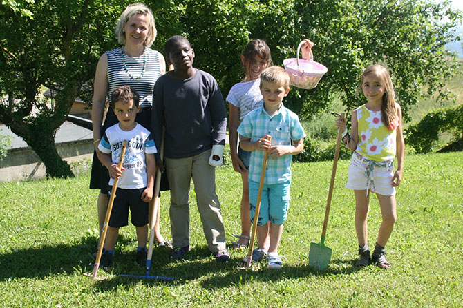 La directrice avec l’équipe de l’été devant les fameux pommiers. Les parents sont aussi mis à contribution, notamment pour assurer l’arrosage du jardin pendant les vacances